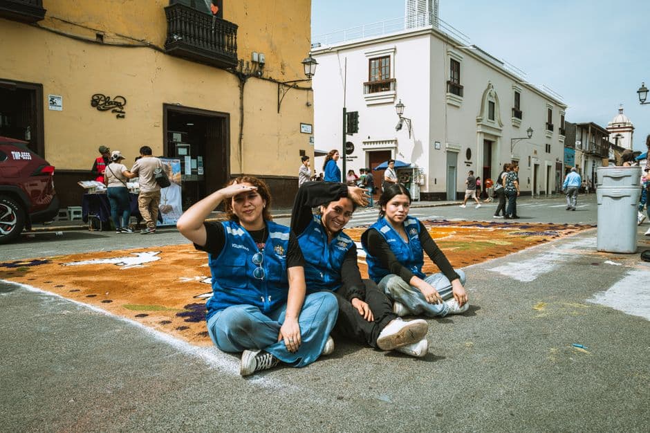 Volunteers sitting on a decorated street during a cultural festival in Trujillo, Peru.