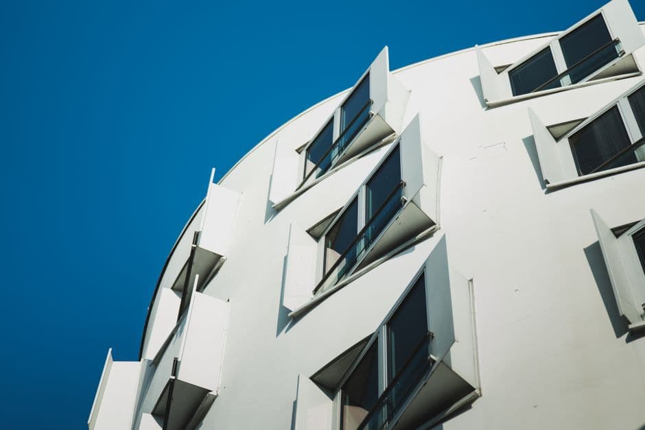 A contemporary building facade with open windows against a clear blue sky in Düsseldorf, Germany.
