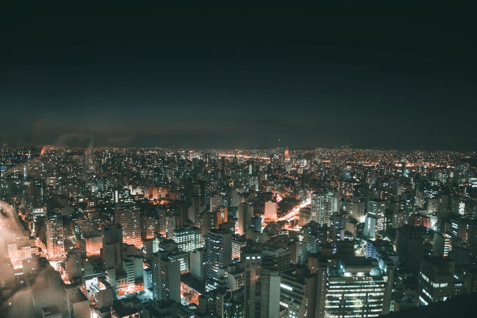 A breathtaking aerial view of city skyscrapers illuminated at night, showcasing urban life and glowing city lights.