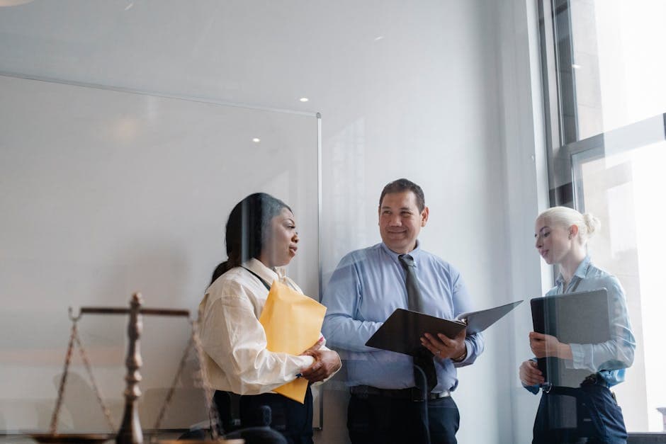 Through glass of group positive multiethnic lawyers in formal clothes standing in office with documents and discussing details of new case