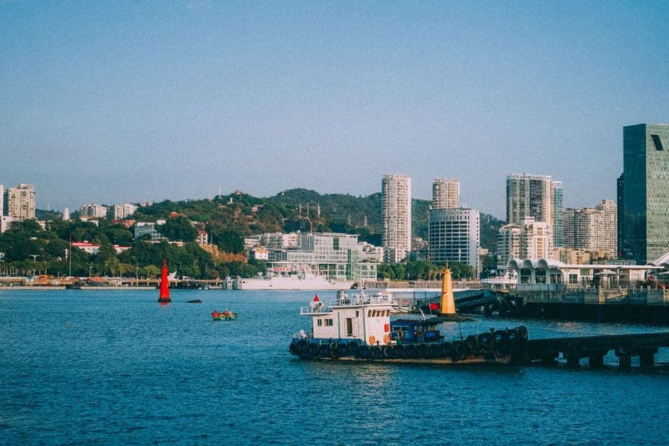 Scenic view of a vibrant coastal city with modern skyscrapers and bustling harbor.
