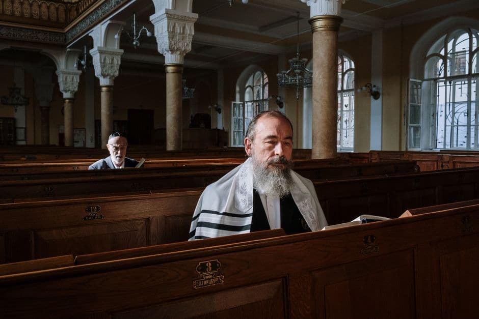 Two Orthodox men praying inside a historic synagogue, symbolizing faith and tradition.