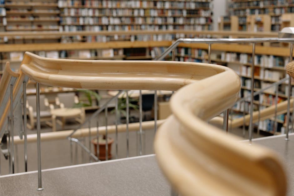 A detailed shot showcasing the design and architecture of a university library's curved handrail and bookshelves.