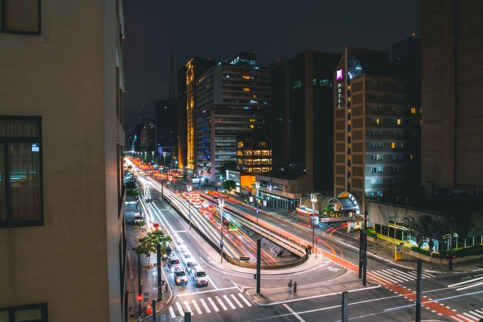 Dynamic night view of São Paulo with bustling traffic and illuminated buildings.