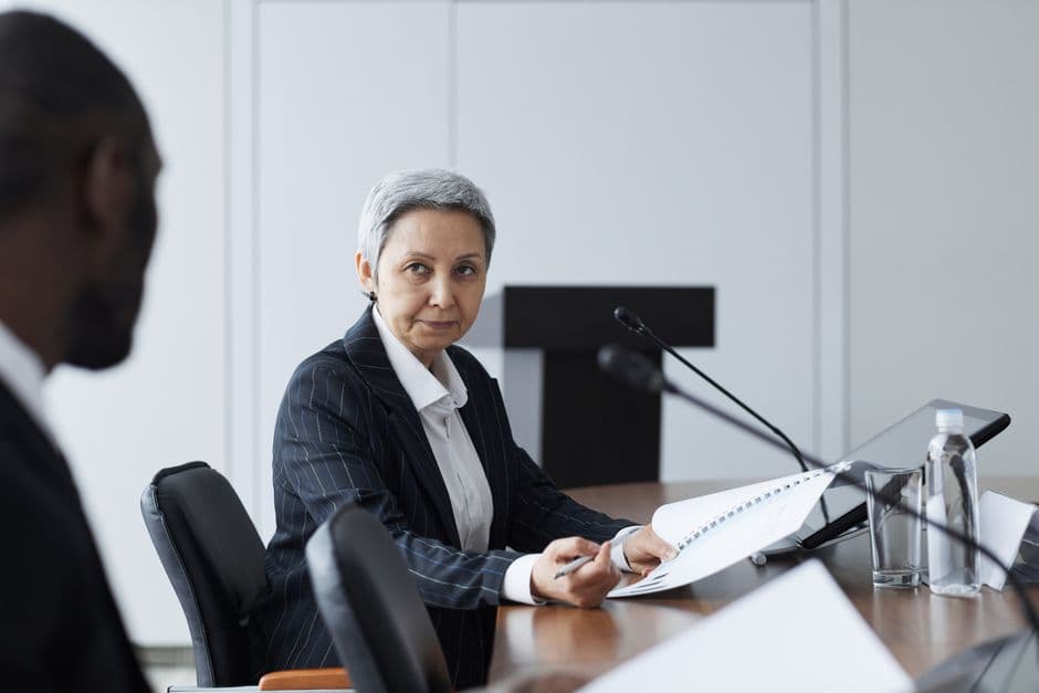 Senior businesswoman leading a conference discussion with a diverse team.