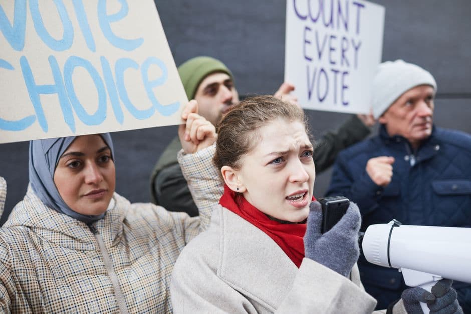 People protesting with signs demanding fair voting practices and choice.
