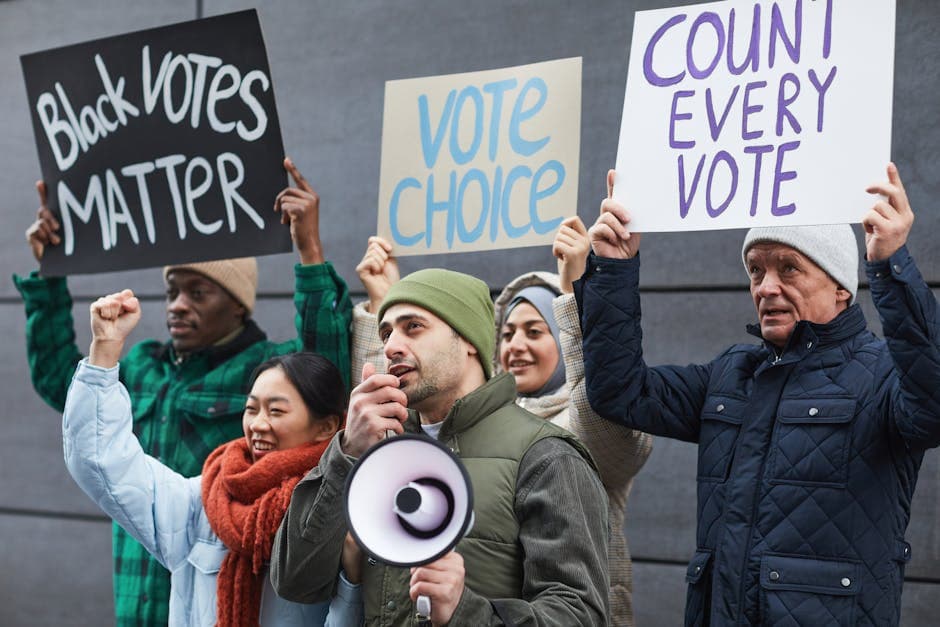 Group of diverse individuals protesting for voting rights with placards and megaphone.