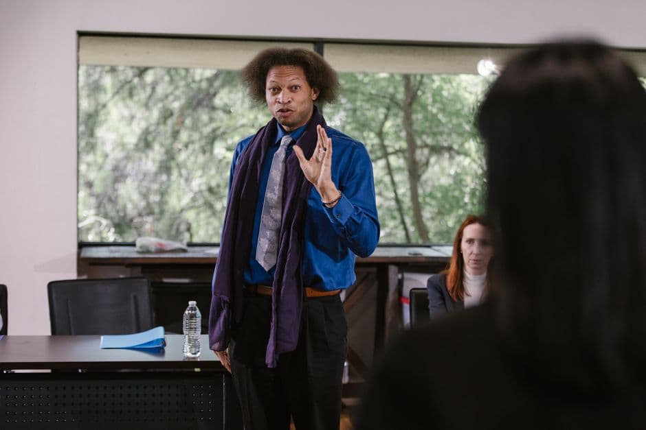 Business professional presenting to an attentive audience in a modern seminar setting.
