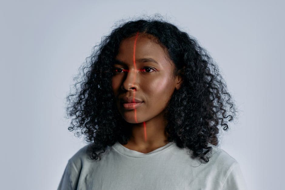 Portrait of a woman with facial recognition technology lines across her face on a plain background.