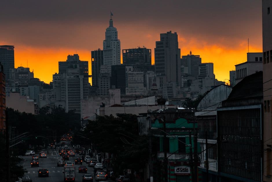 A captivating skyline view of a bustling city during sunset with an orange sky backdrop.