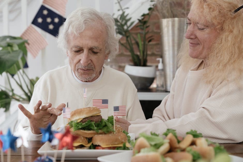 Elderly couple enjoying burgers with American decor, perfect for July 4th celebrations.