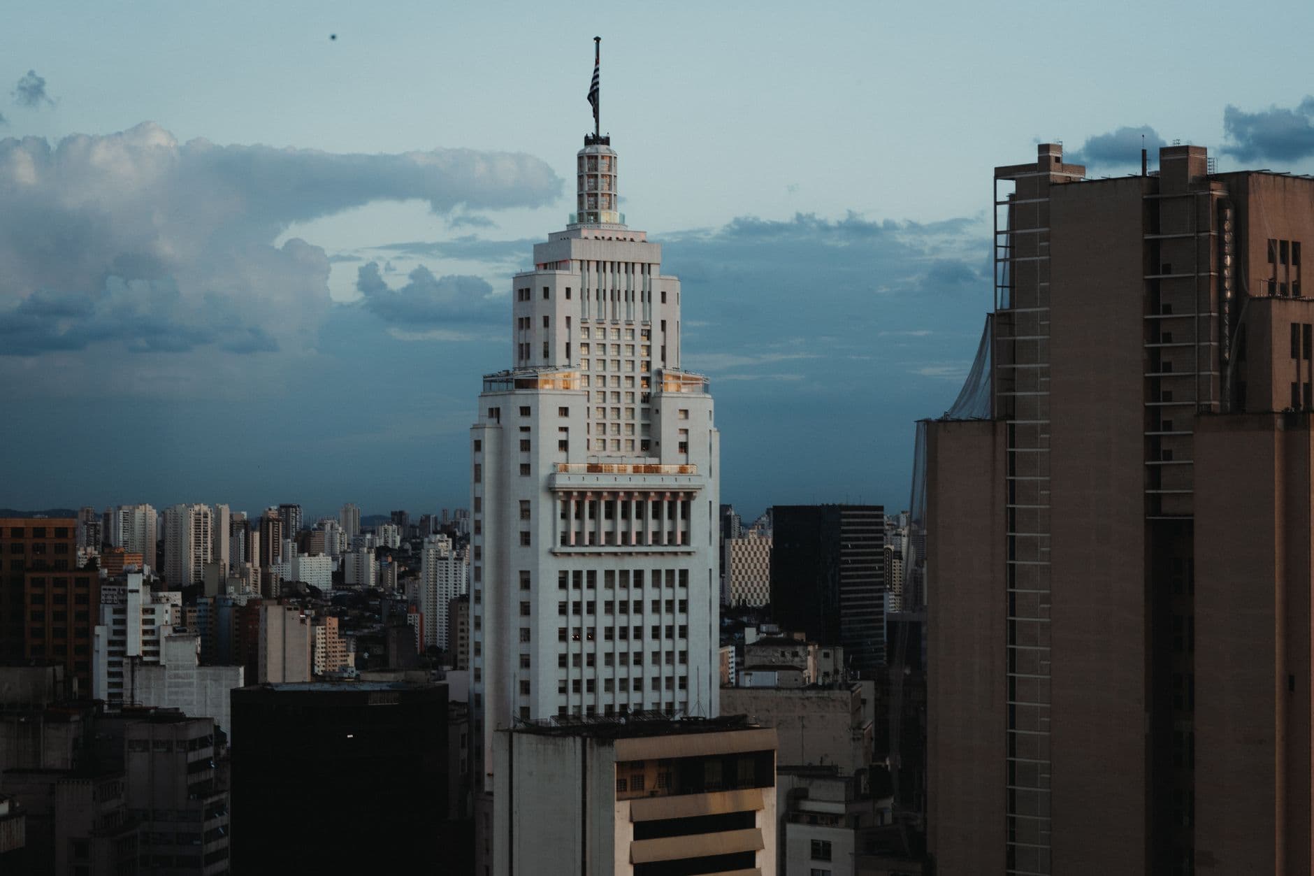 A striking view of an iconic skyscraper in São Paulo's cityscape against a cloudy sky.