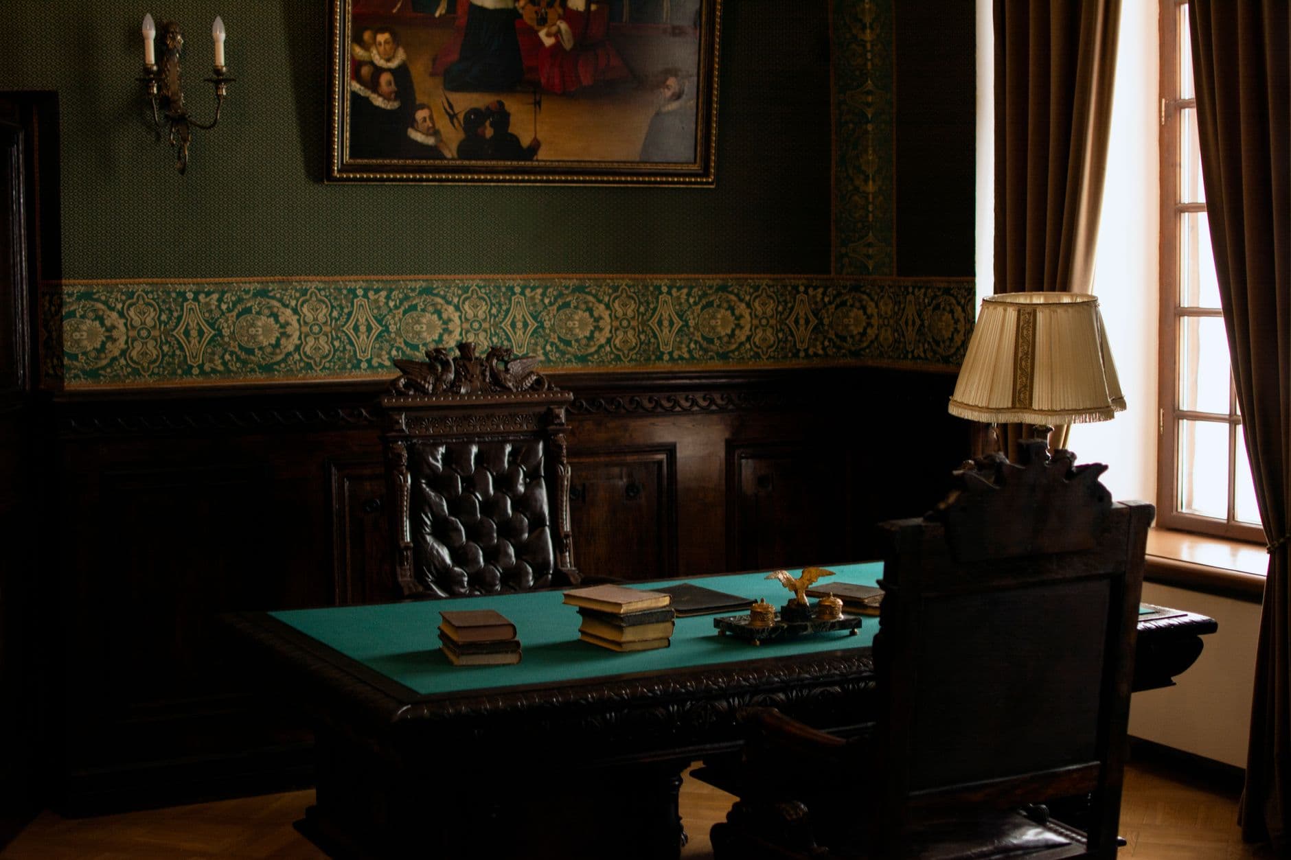 Luxurious antique office interior in a historic palace setting featuring an old-fashioned wooden desk and chair.