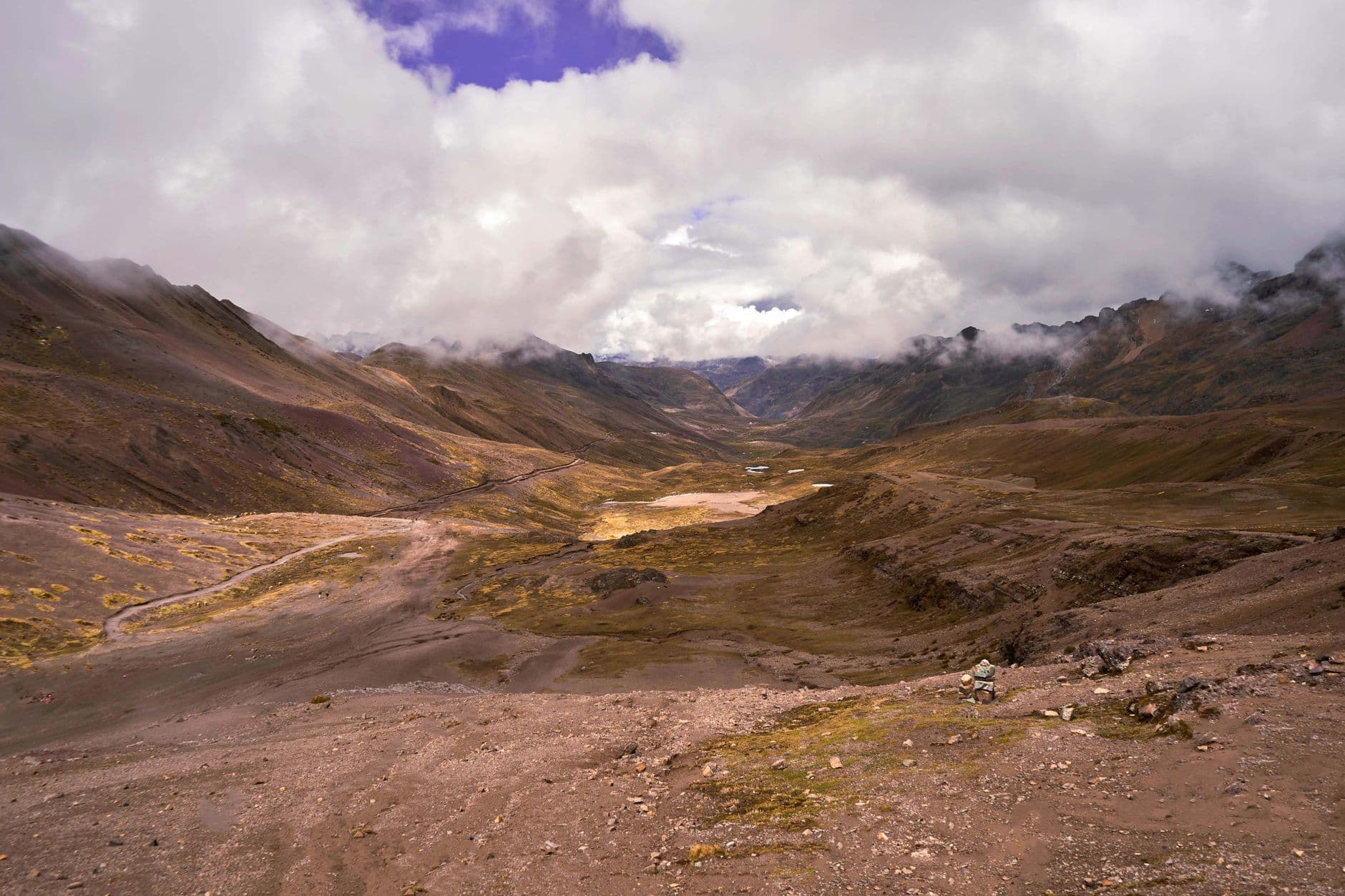 Beautiful empty mountain valley with clouds and rugged terrain.