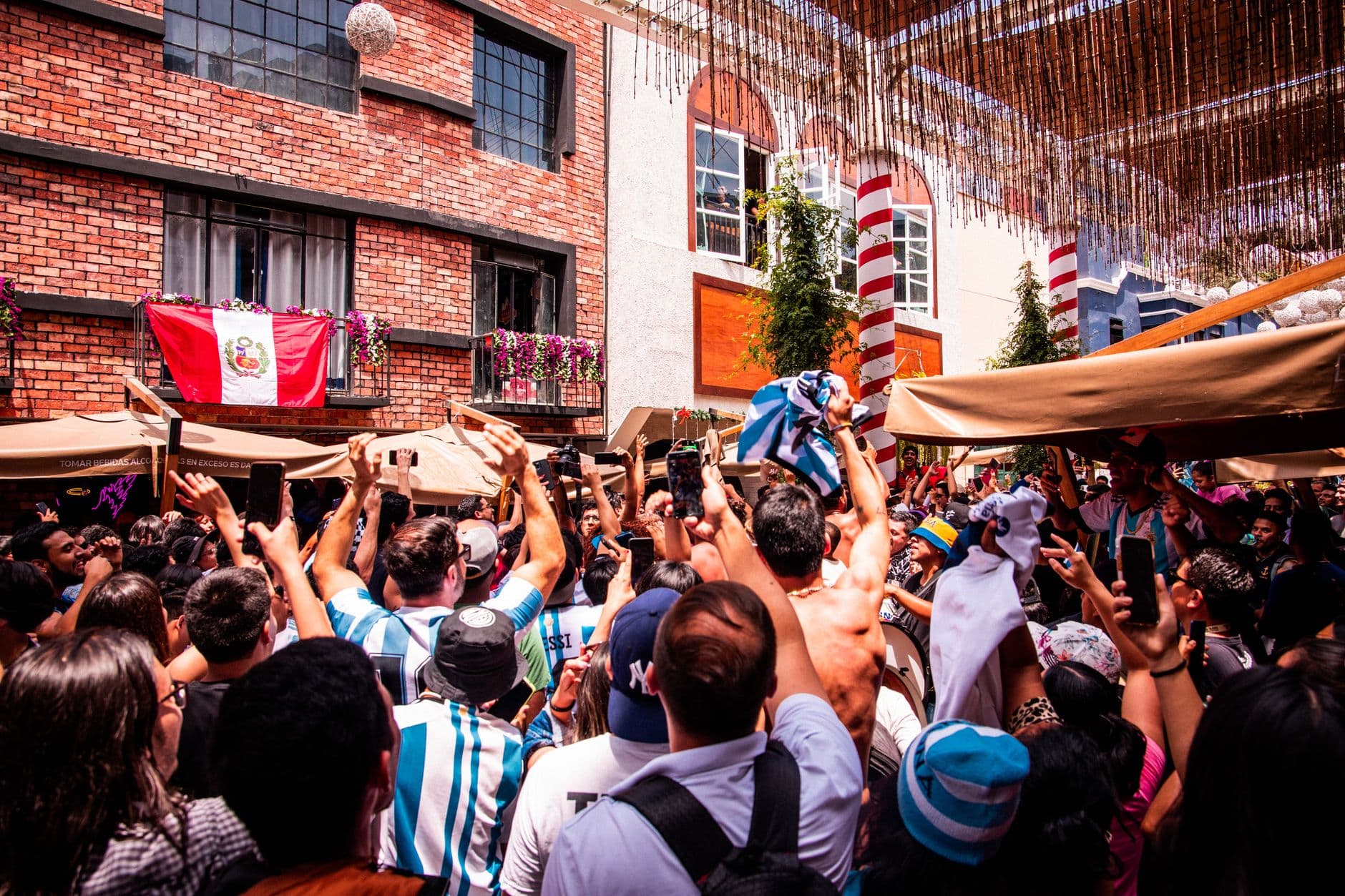 A lively crowd cheering with flags in Lima, Peru, showcasing cultural celebration and community spirit.
