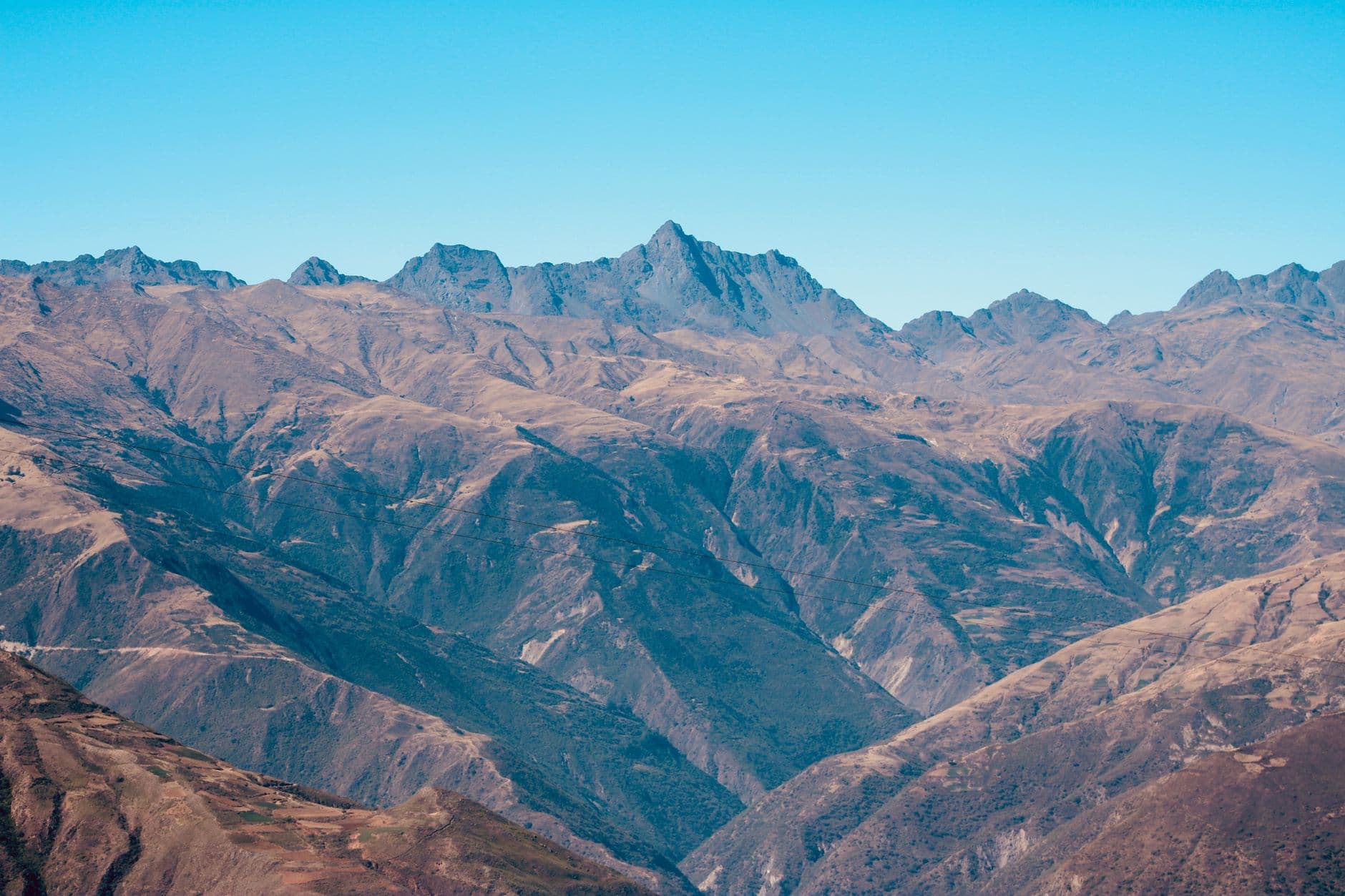 Majestic mountain range captured from above under a clear blue sky.