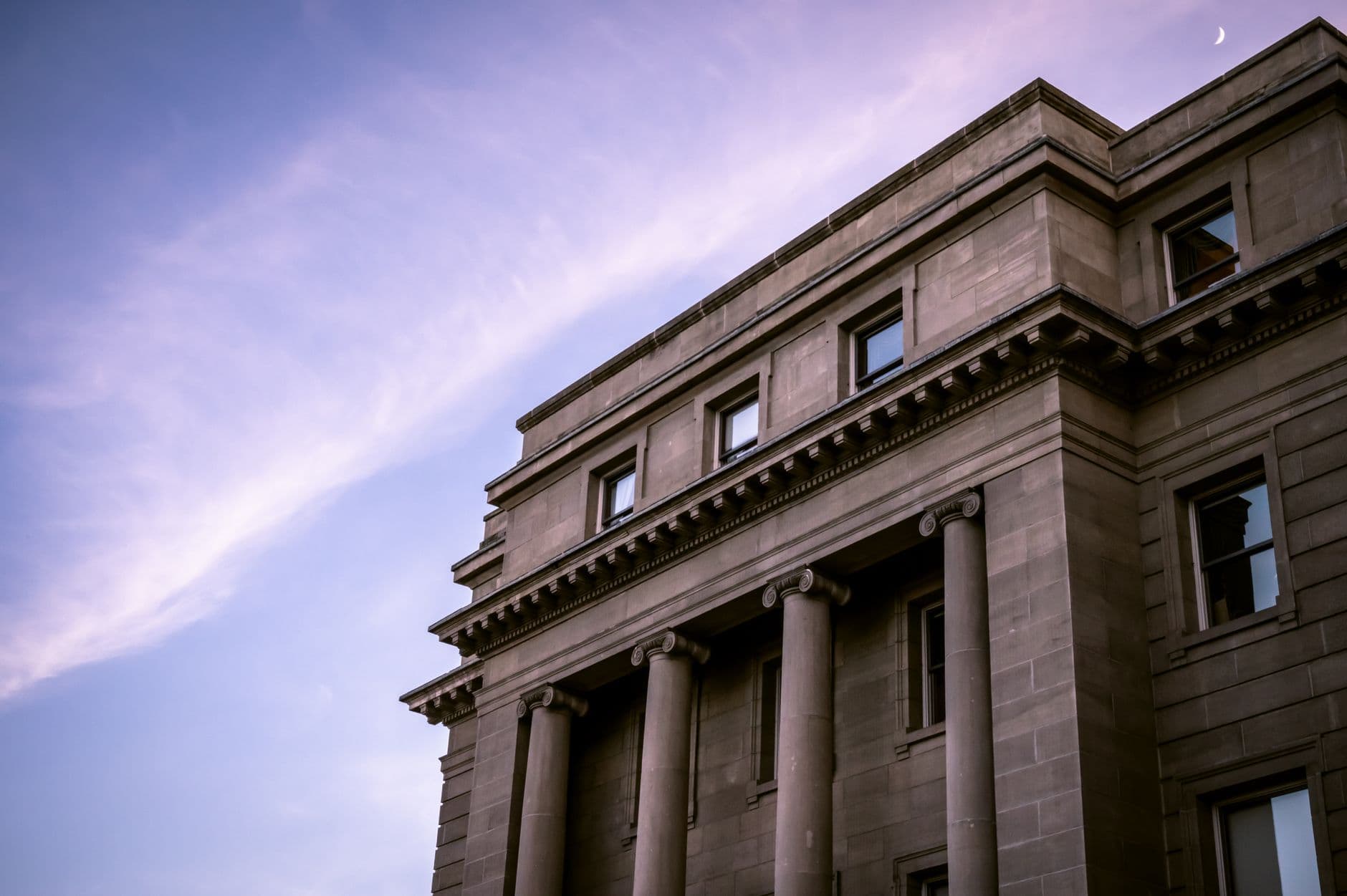 Beautiful neoclassical building with grand columns against a twilight sky, capturing timeless architecture.