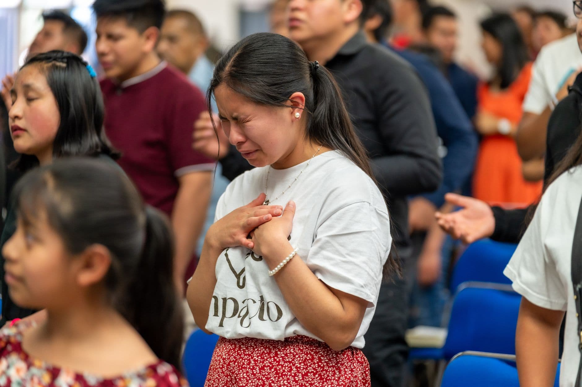 A woman in prayer during a religious gathering in Ciudad de México, showing deep emotion.