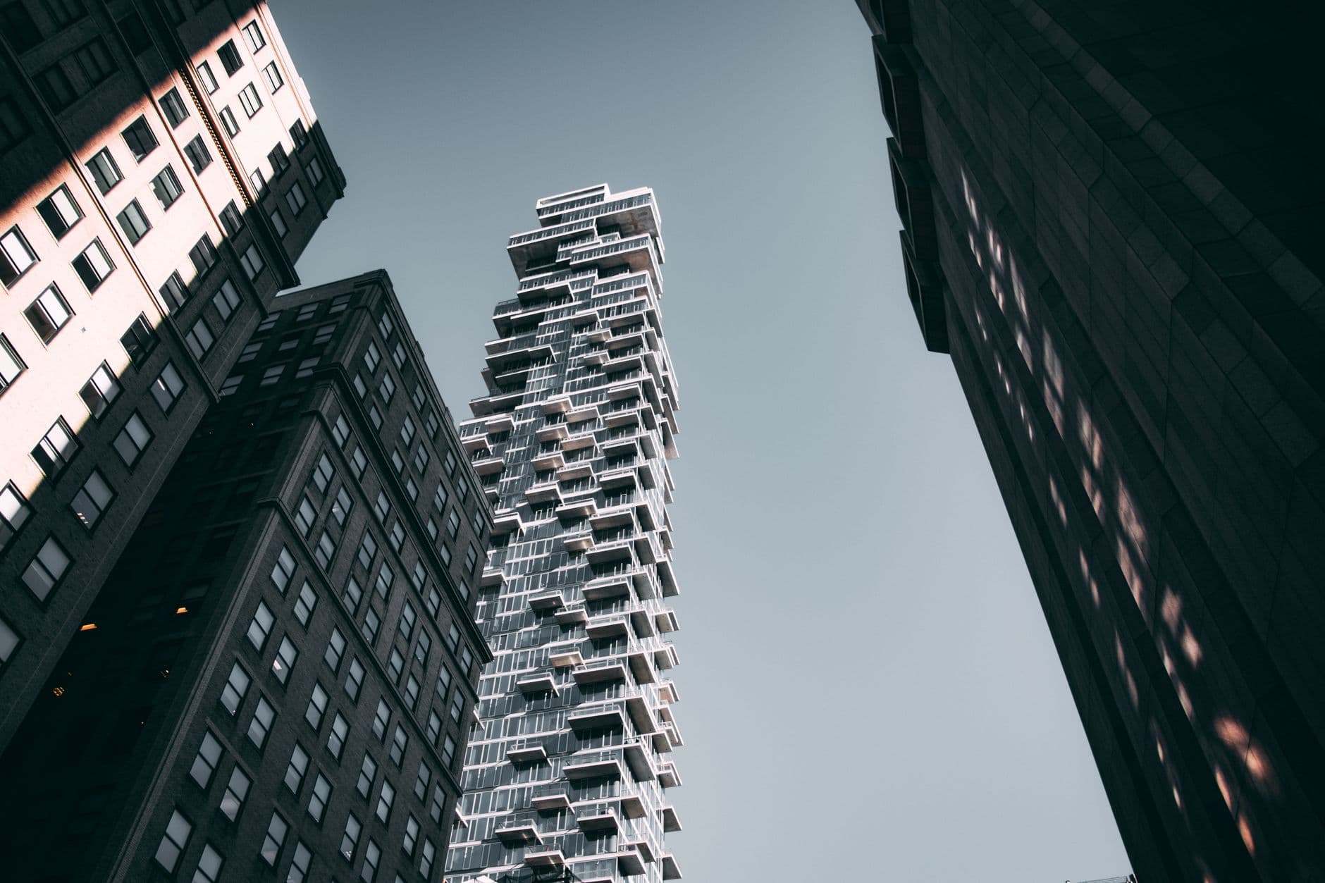 Low-angle view of modern skyscrapers in New York City under a clear sky.