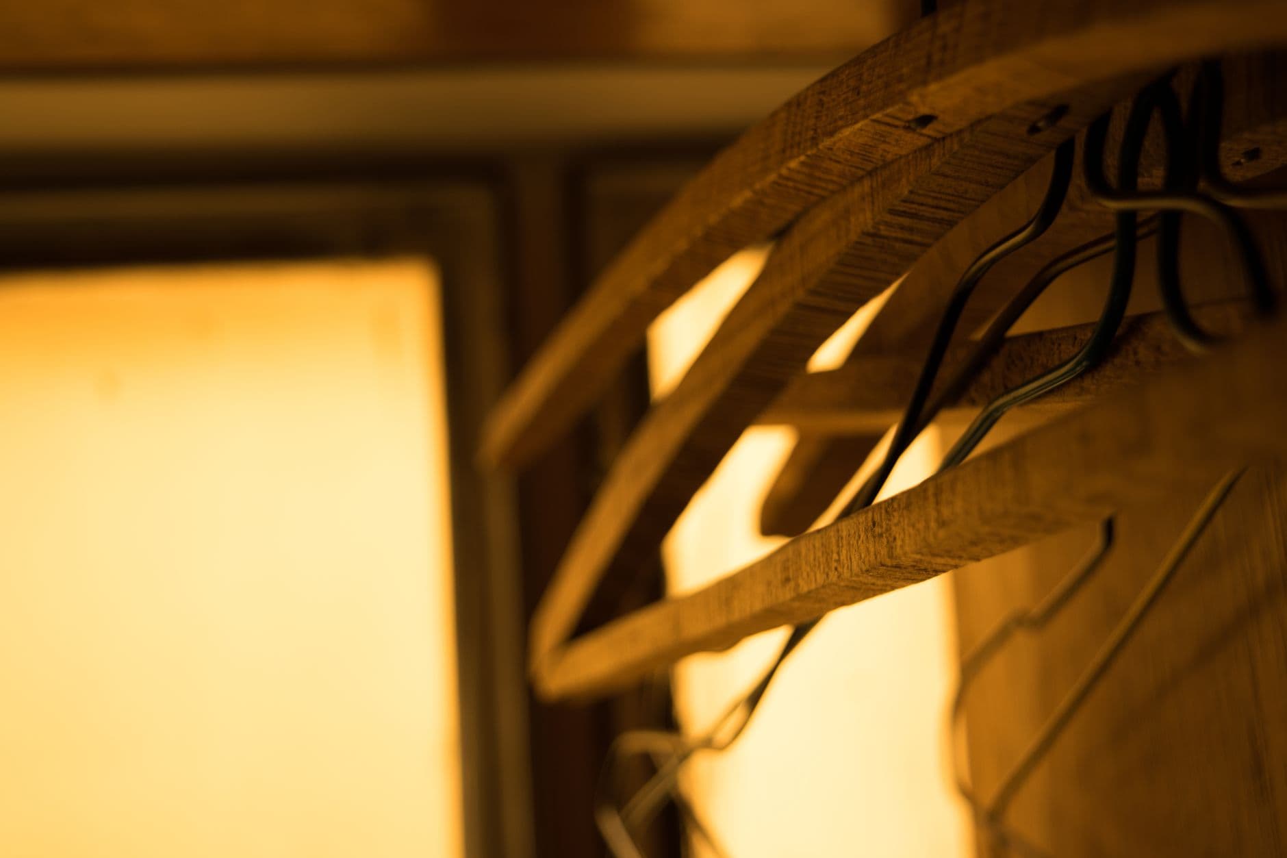 Close-up of wooden hangers with warm lighting, creating a cozy indoor atmosphere.