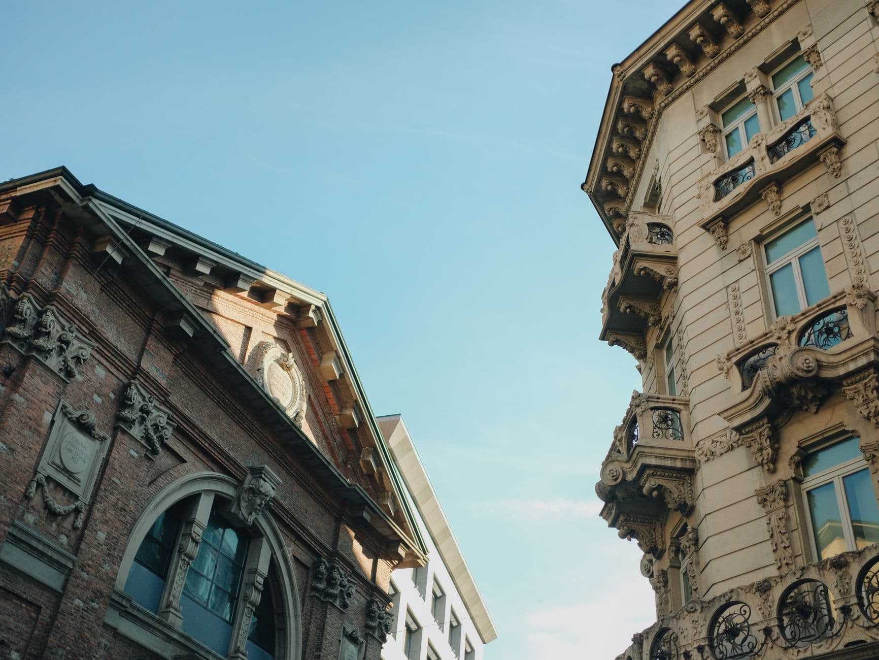 Elegant historic buildings against a clear blue sky in Milan, Italy.