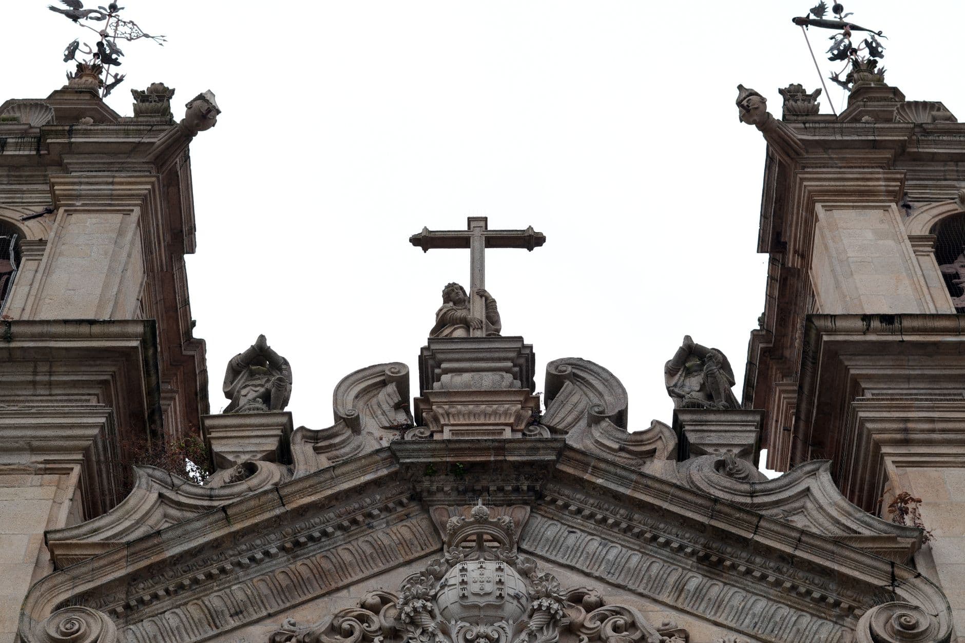Intricate baroque architecture of cathedral in Braga, featuring statues and cross.