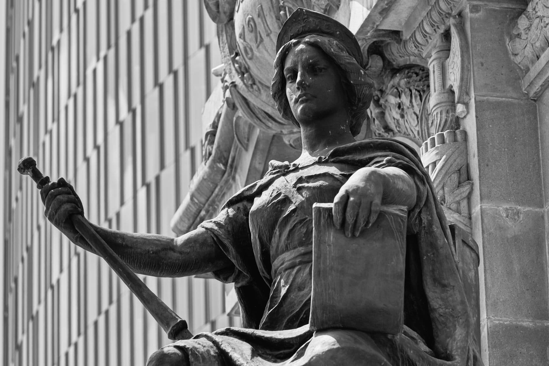 Close-up of a detailed stone statue in black and white.
