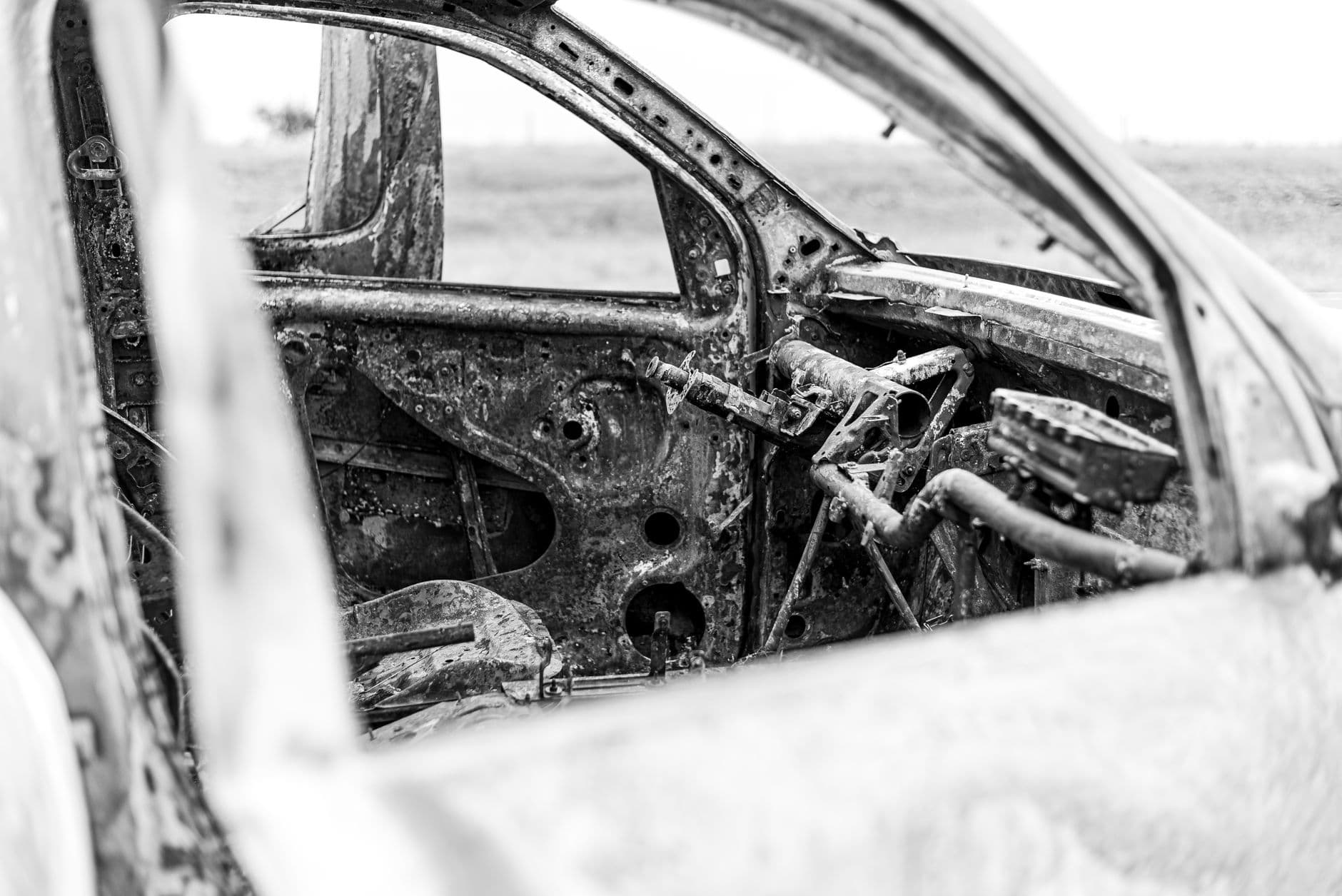 Black and white photo of a rusted, abandoned car's interior in Buenos Aires.