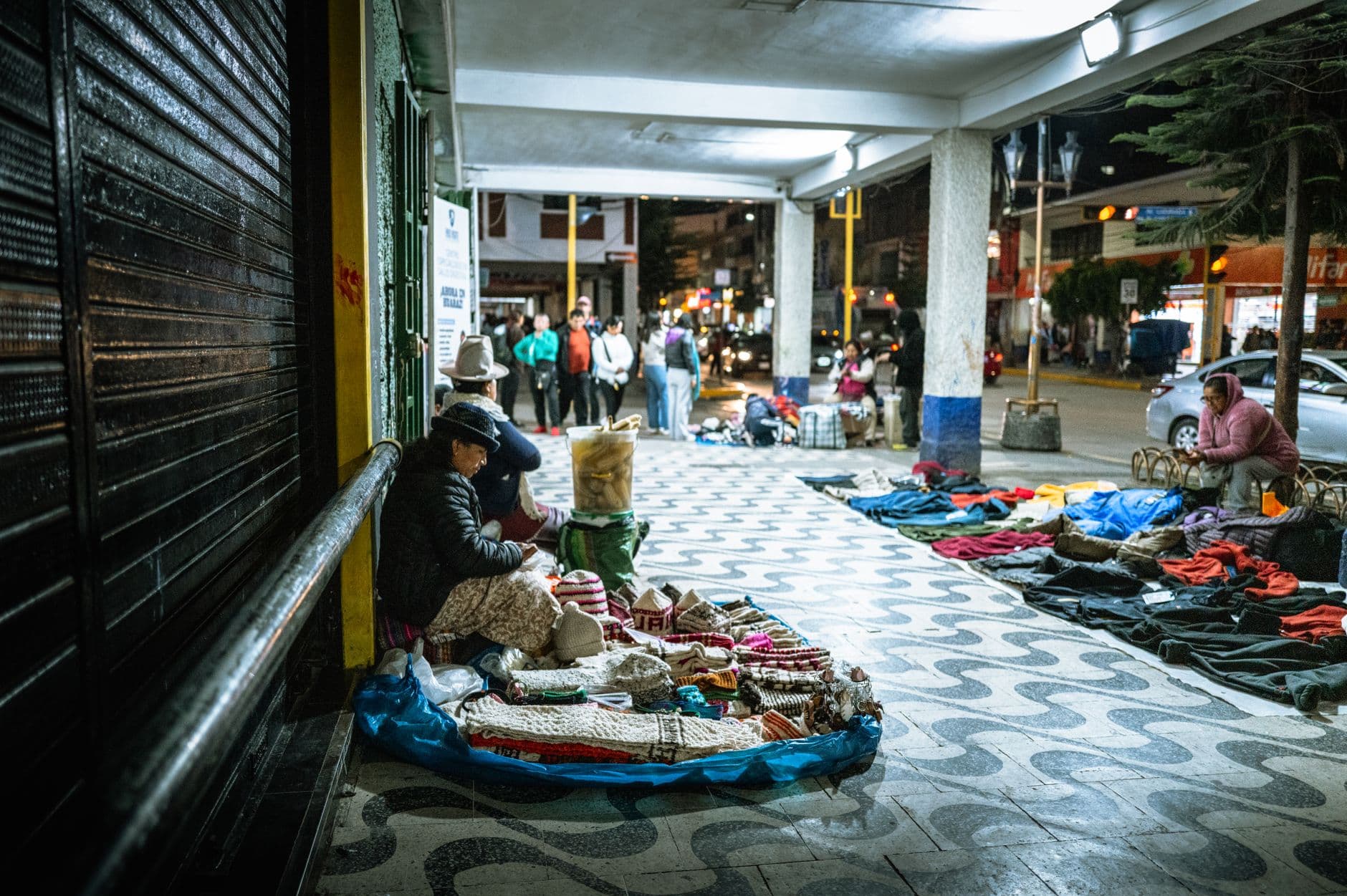 Hispanic vendors at night market selling traditional crafts on a city street in Trujillo, Peru.