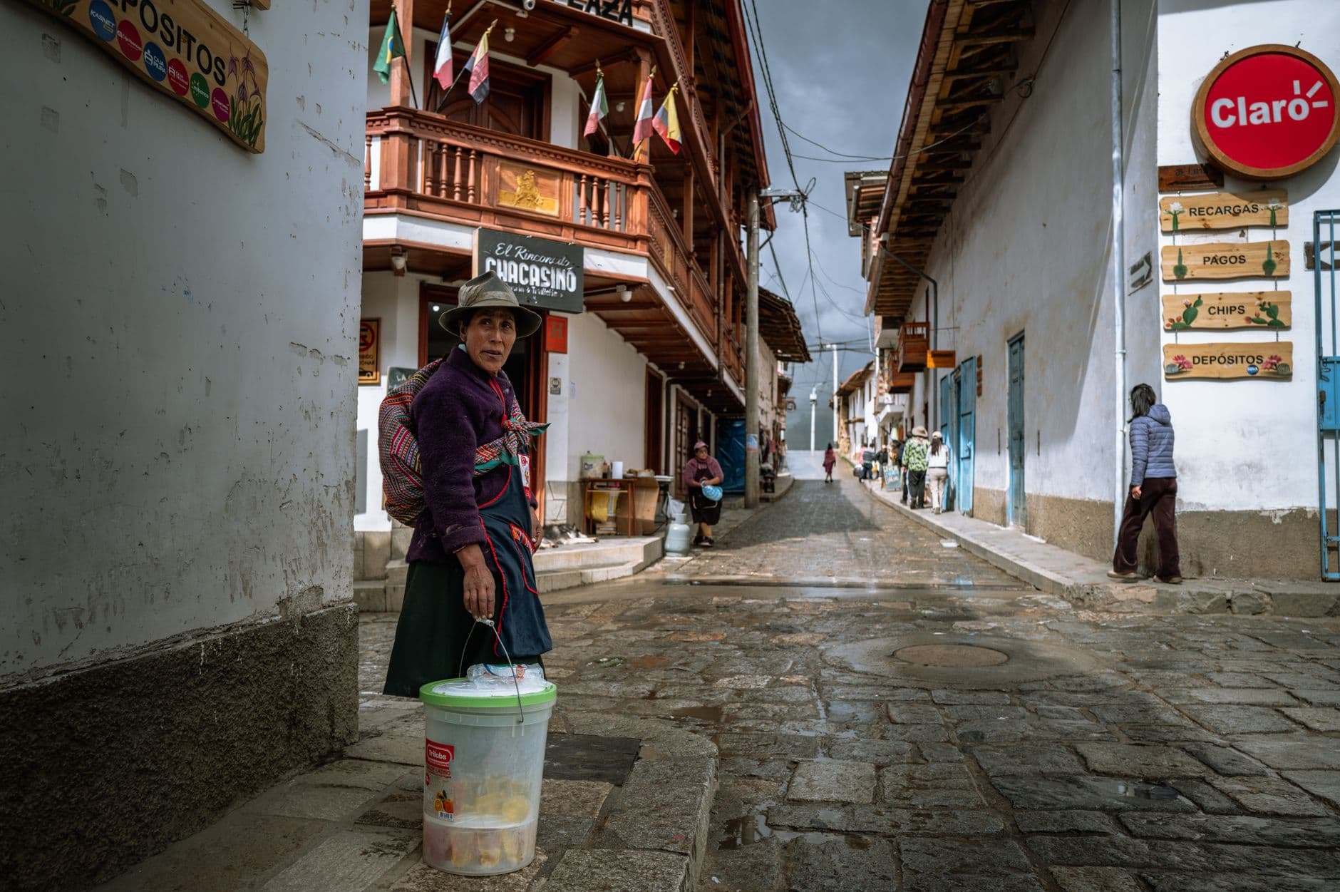 Local Peruvian life on a vibrant street in Huaraz with colorful architecture.