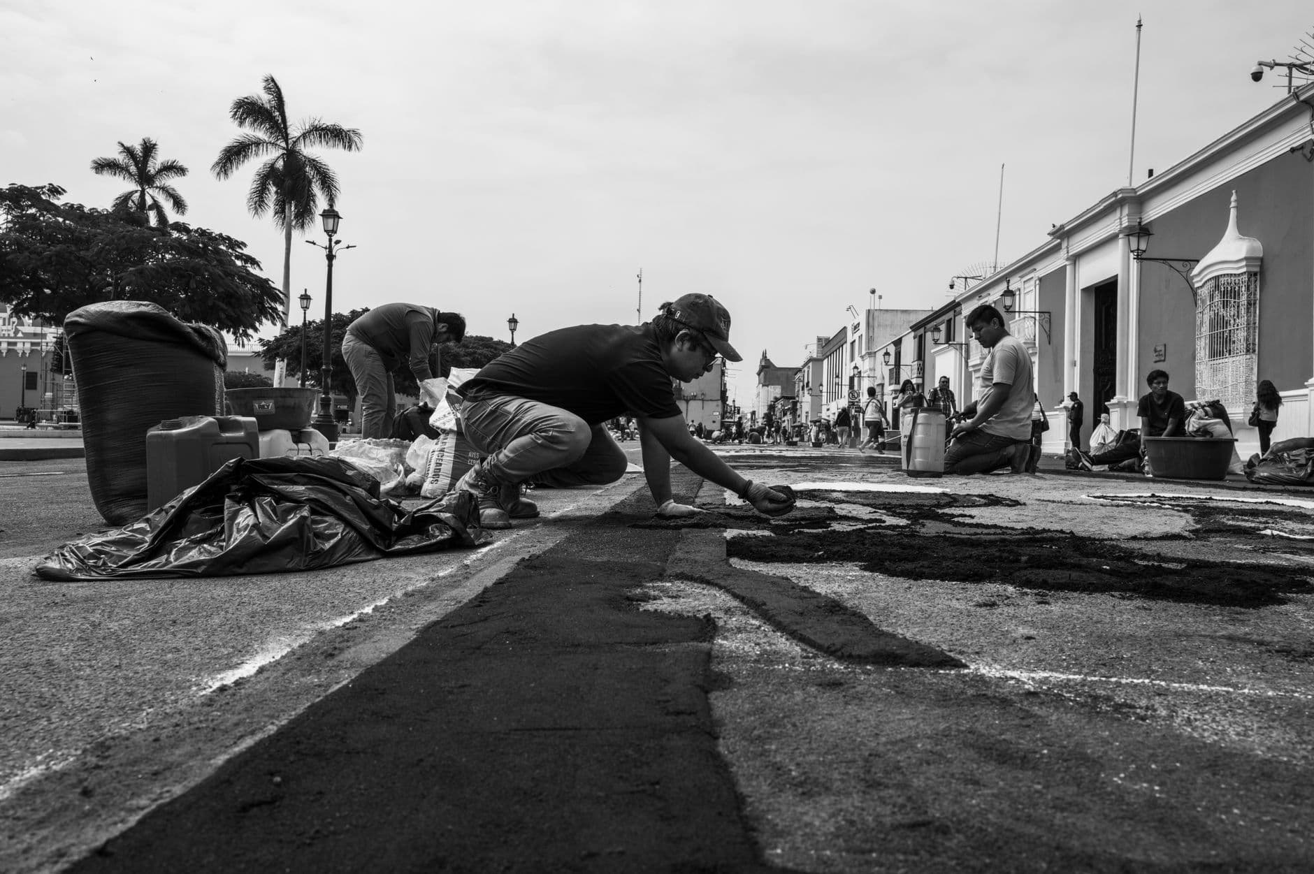 Street artists in Trujillo, Peru, create a mural, capturing cultural expressions in black and white.