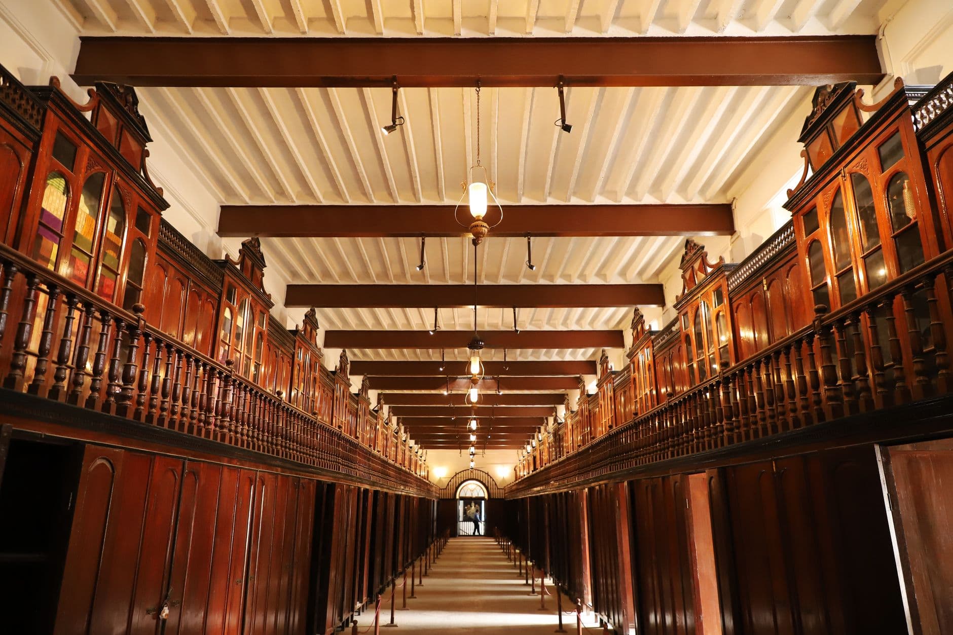 A view of a historical library interior showcasing intricate wooden archways and high ceilings with bright lighting.
