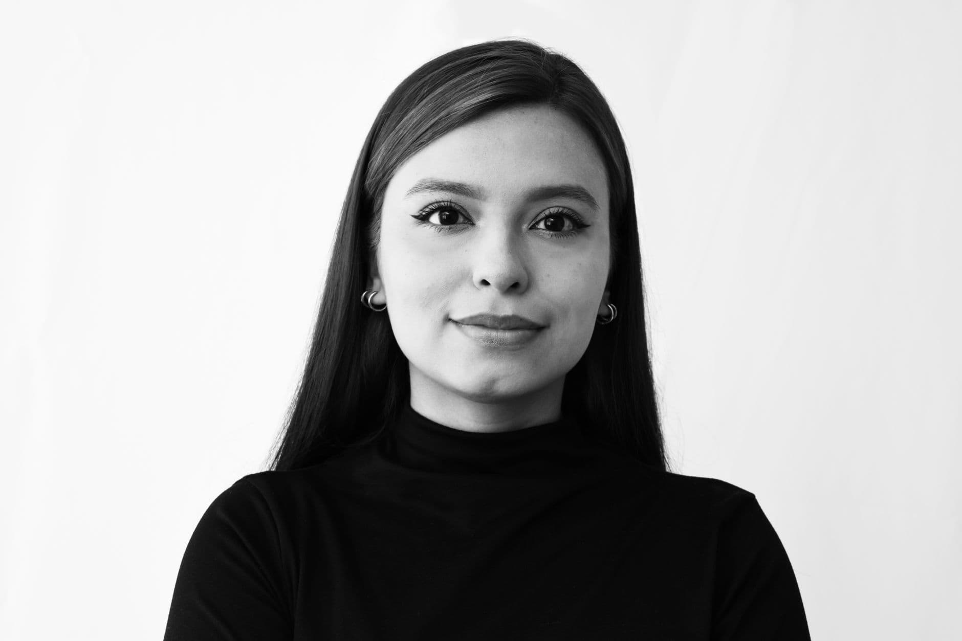 Elegant black and white portrait of a confident young woman with long hair and earrings.