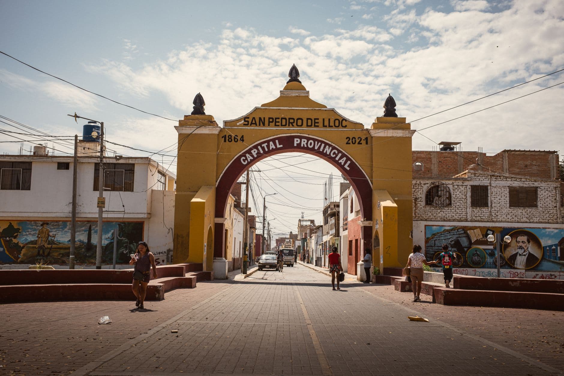 Street view of the archway in San Pedro de Lloc, Peru, showcasing vibrant urban life.
