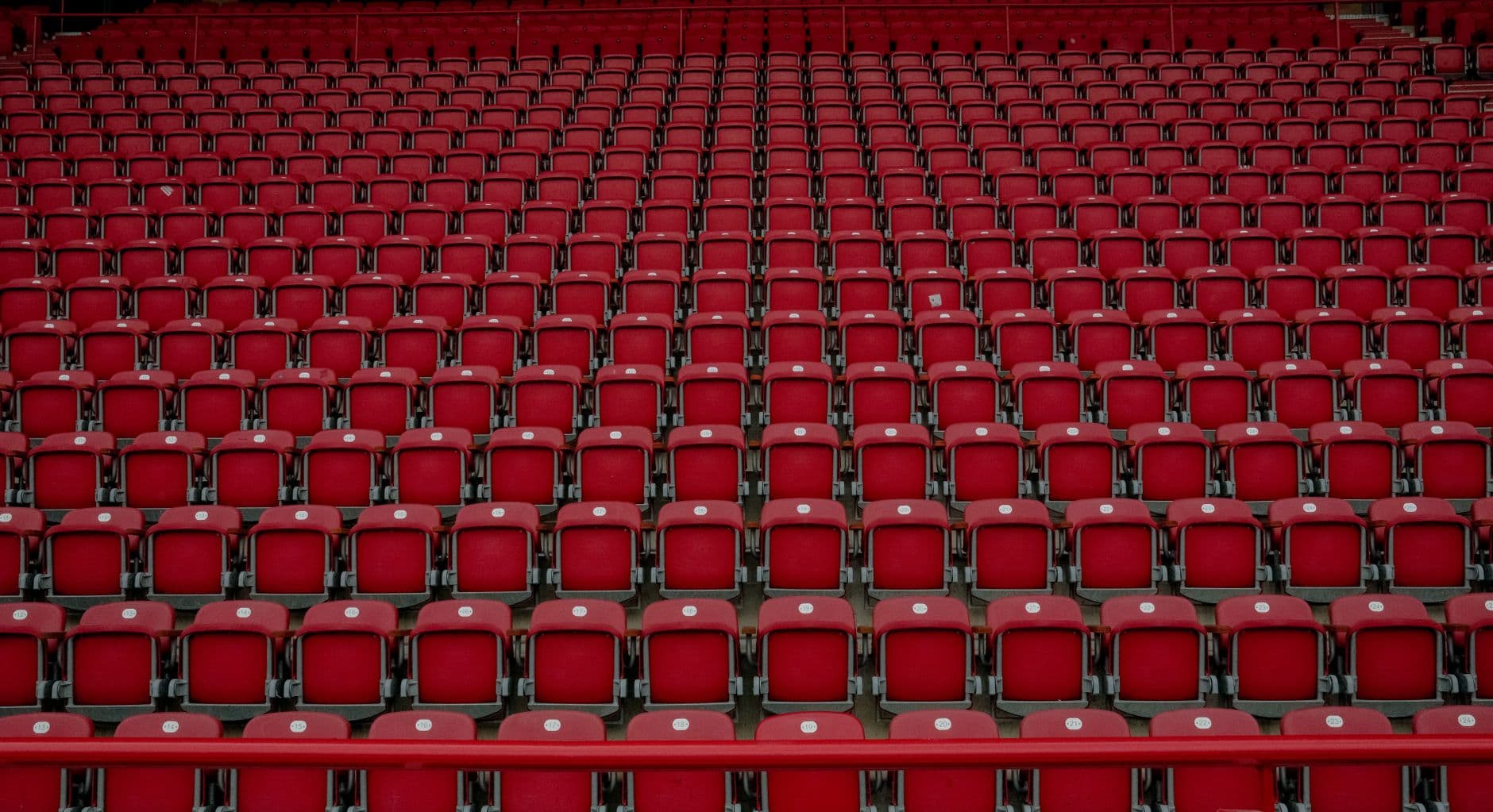 Rows of empty red seats in a Berlin stadium, creating a symmetrical pattern.