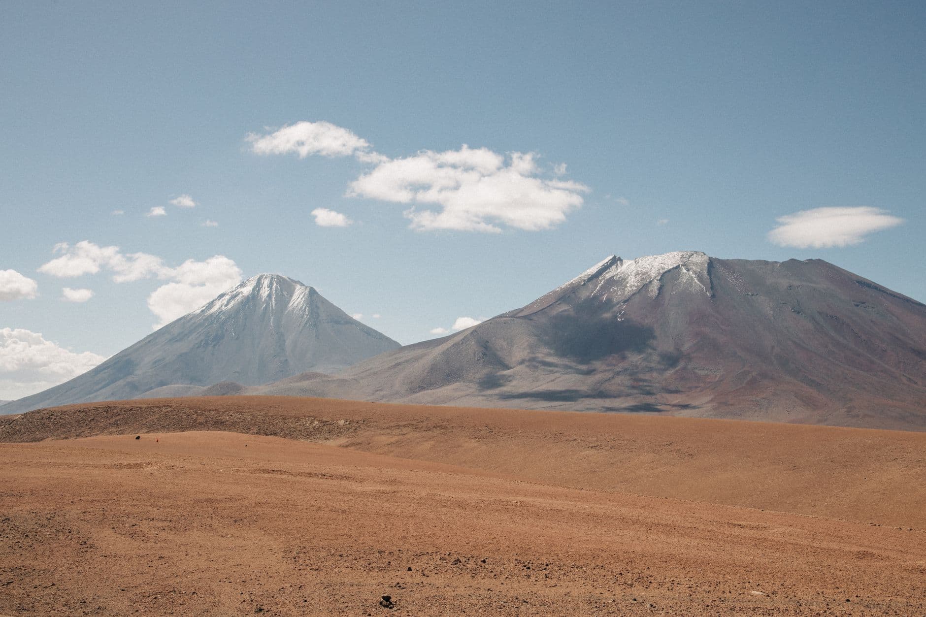 A stunning view of snow-capped mountains in Chile's Andes under a clear blue sky.