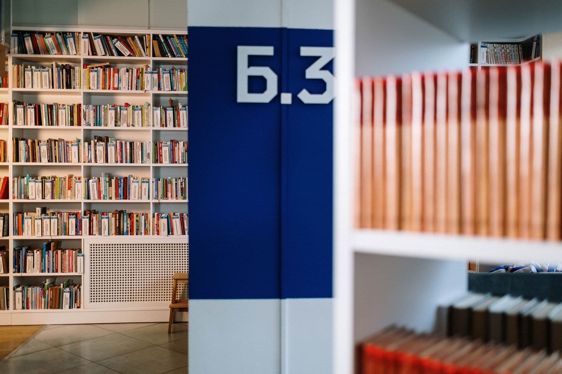 Cozy library interior showcasing bookshelves and aisle signage, perfect for reading enthusiasts.