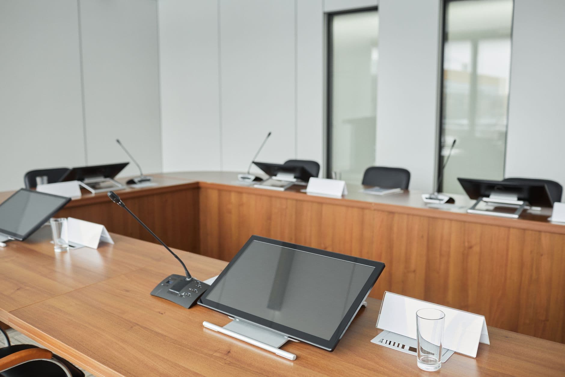 Spacious conference room equipped with modern technology and microphones for meetings.