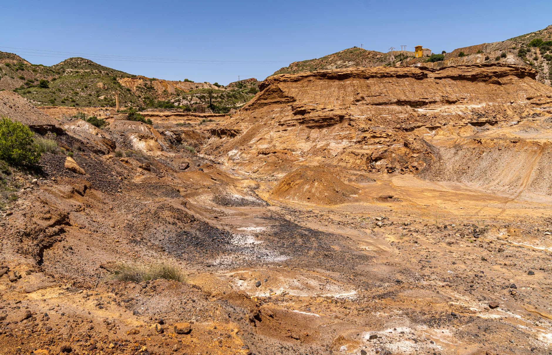 Dry and eroded landscape showcasing rugged, arid terrain with visible geological layers.