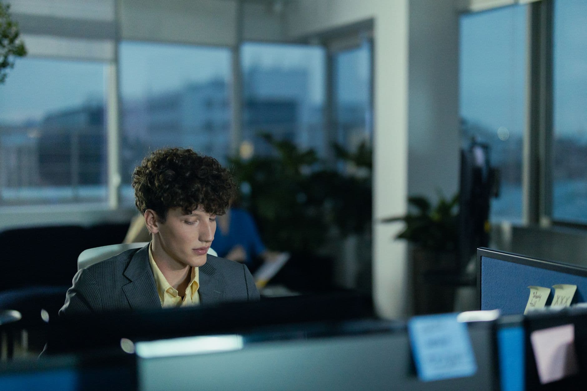 Young man focused on work in a modern office environment at night.