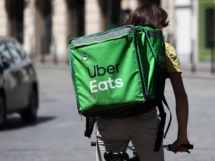 A sticker with a heart in Ukrainan flag colours is seen on a bag of Uber Eats courier riding a street in Krakow, Poland on June 22, 2022. (Photo by Jakub Porzycki/NurPhoto)